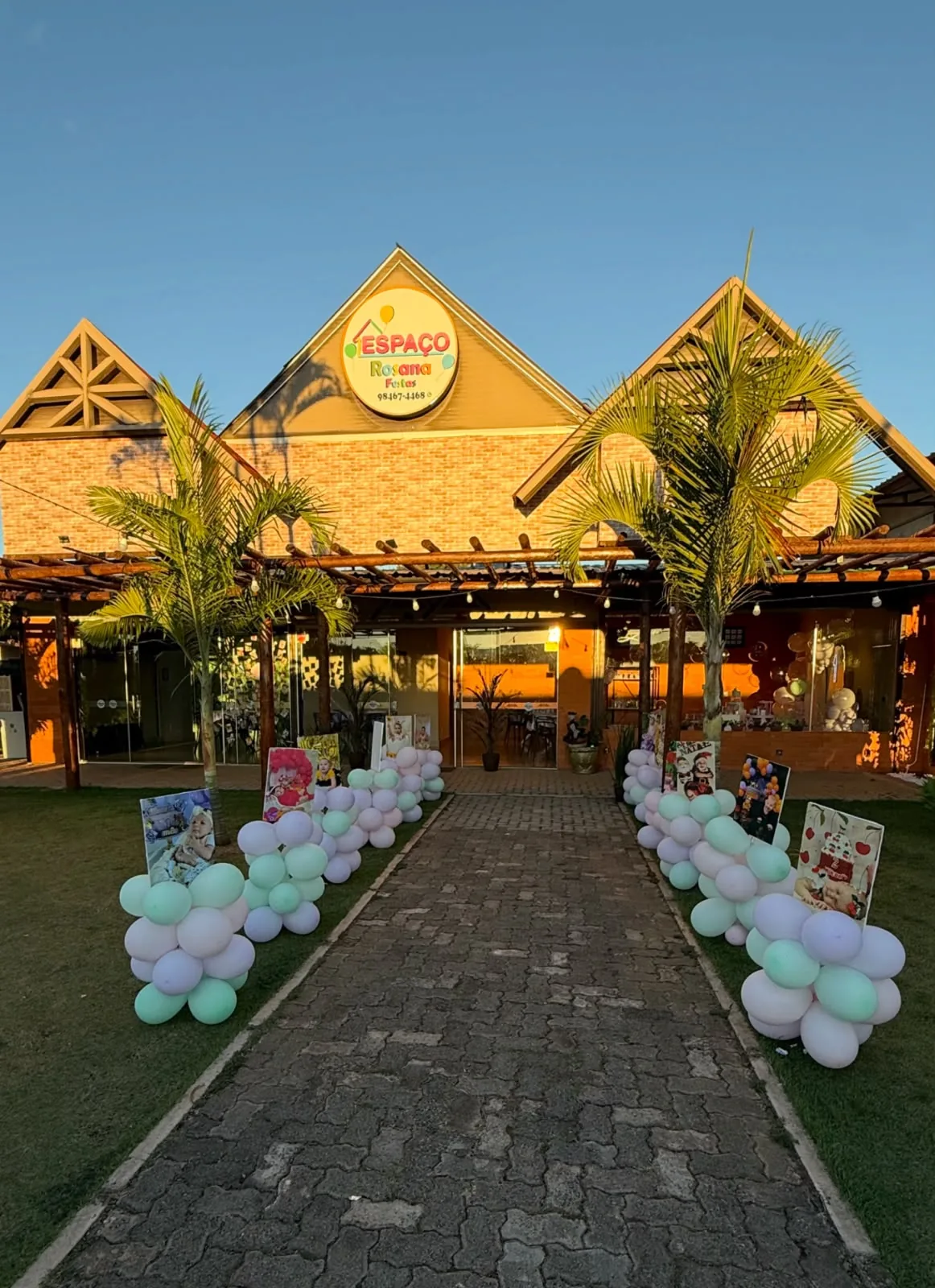 Caminho de pedra até a fachada do Espaço Rosana Festas, decorado com balões em tons pastel