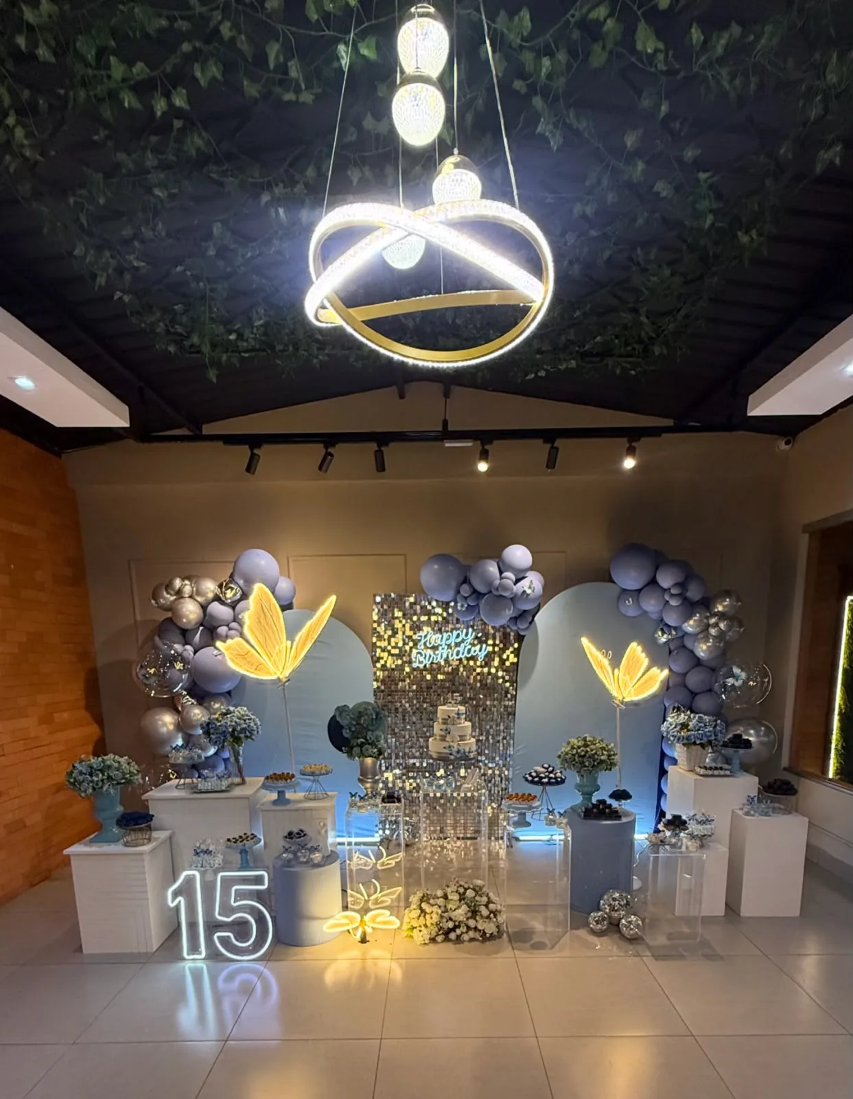 Salão decorado para uma festa de 15 anos, com a luminária no teto de folhagem